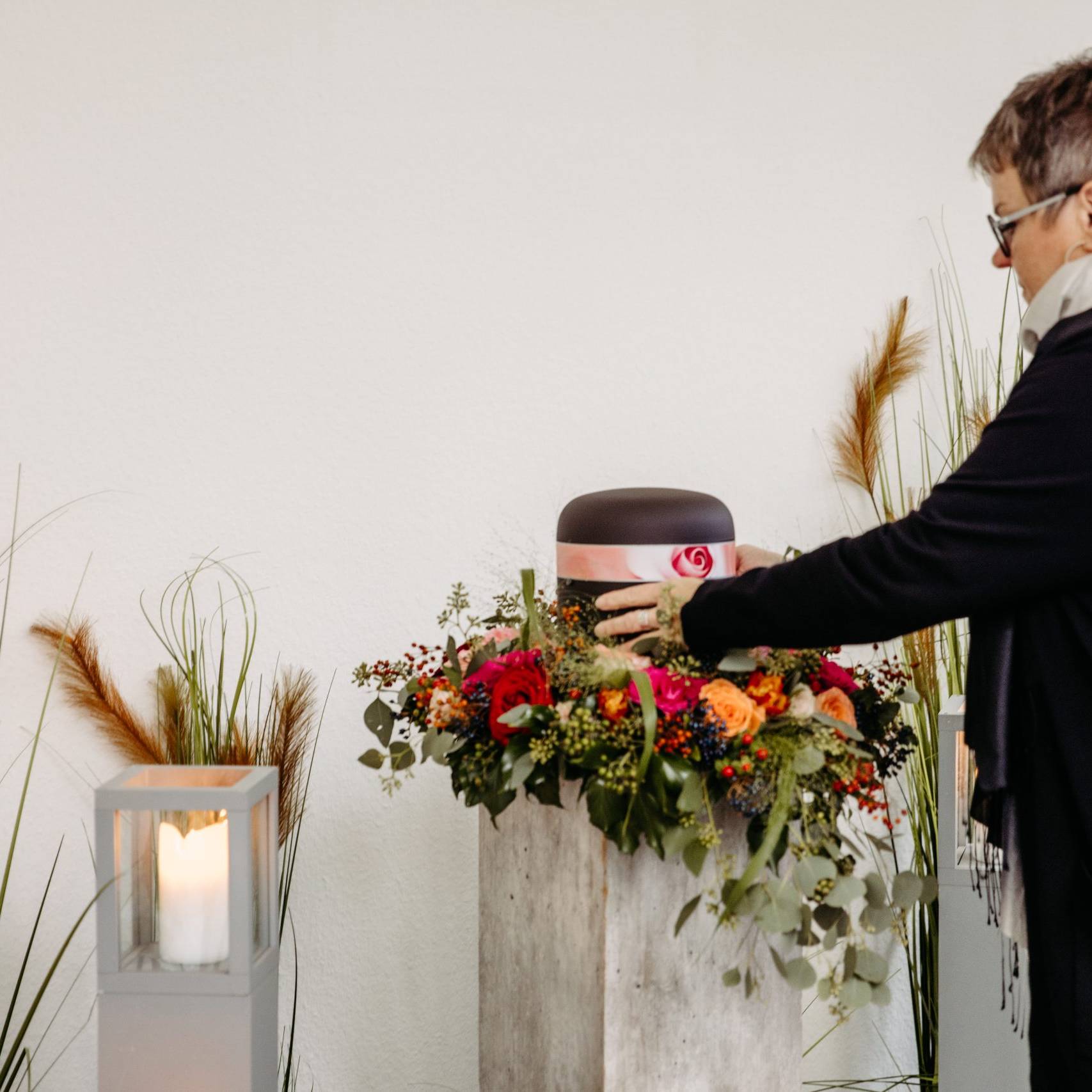 Frau stellt Urne mit Dekoration zusammen