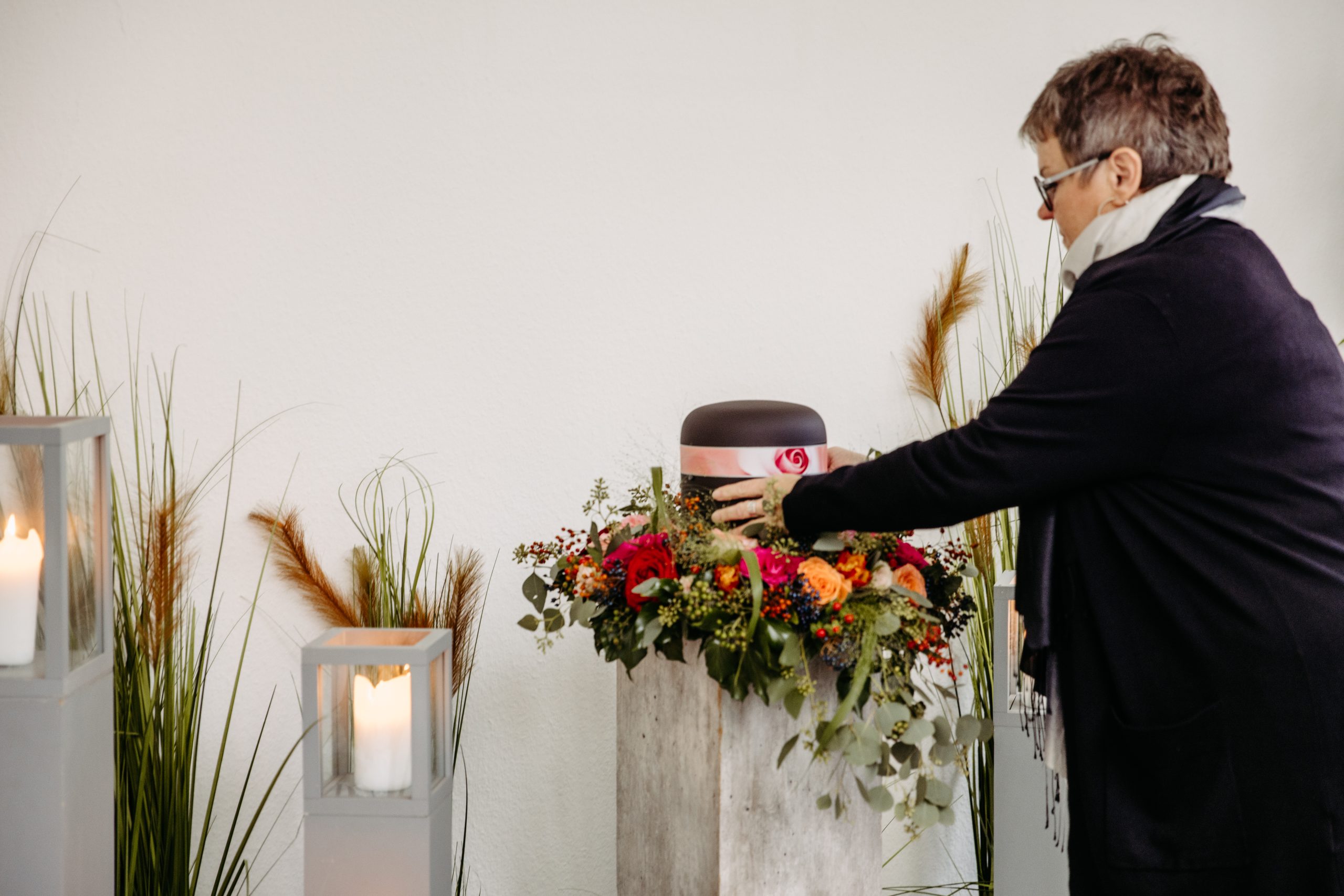 Frau stellt Urne mit Dekoration zusammen